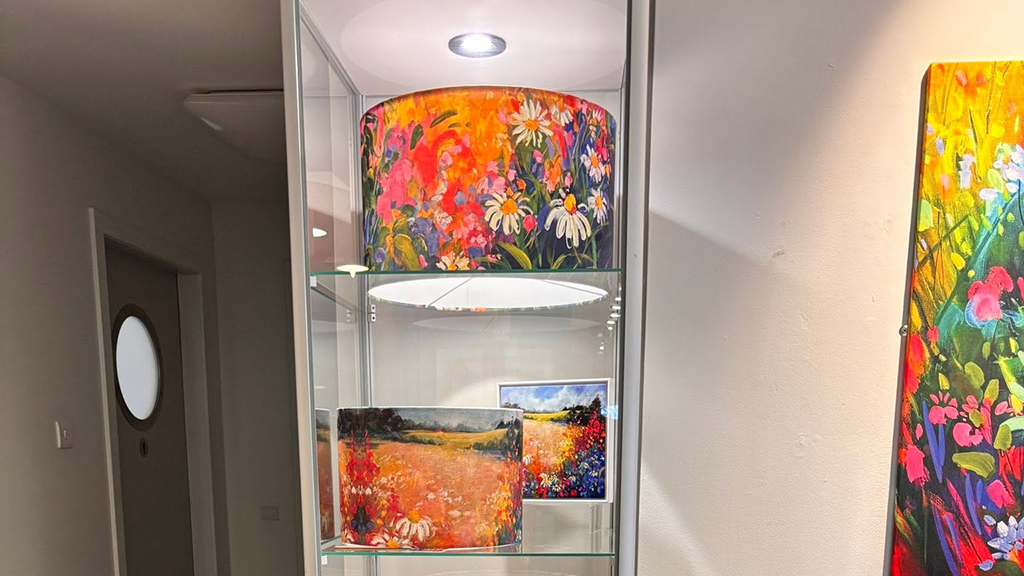 Two lampshades and a painting in a display cabinet at the Harbour Arts Centre