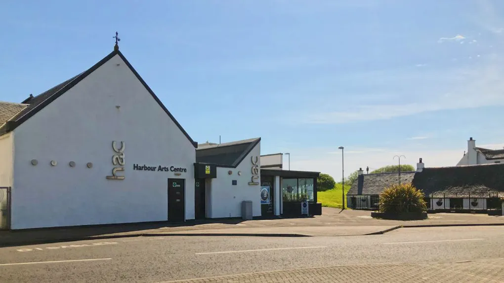 Harbour Arts centre viewed from the front, a white building with blue sky behind.